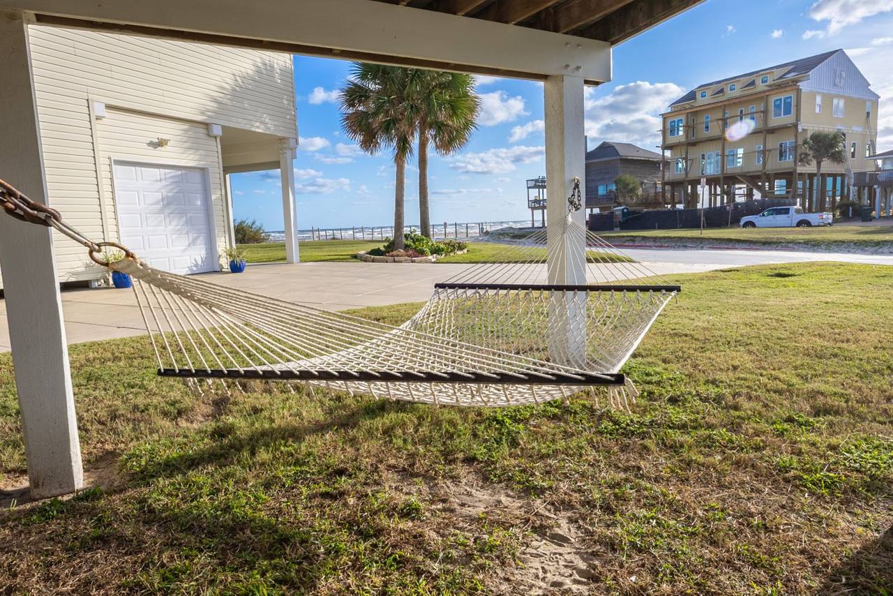 Hammock under the house, with palms and the Gulf just beyond